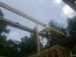 Carpenter setting a ridge beam over a new addition frame — Ice Dam Removal by Roofing Brothers in Cook