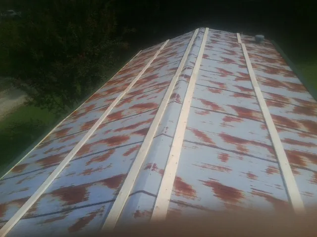Rusted metal roof panels with new wood purlins before replacement — Storm Damage Roof Repair in Cook by Roofing Brothers